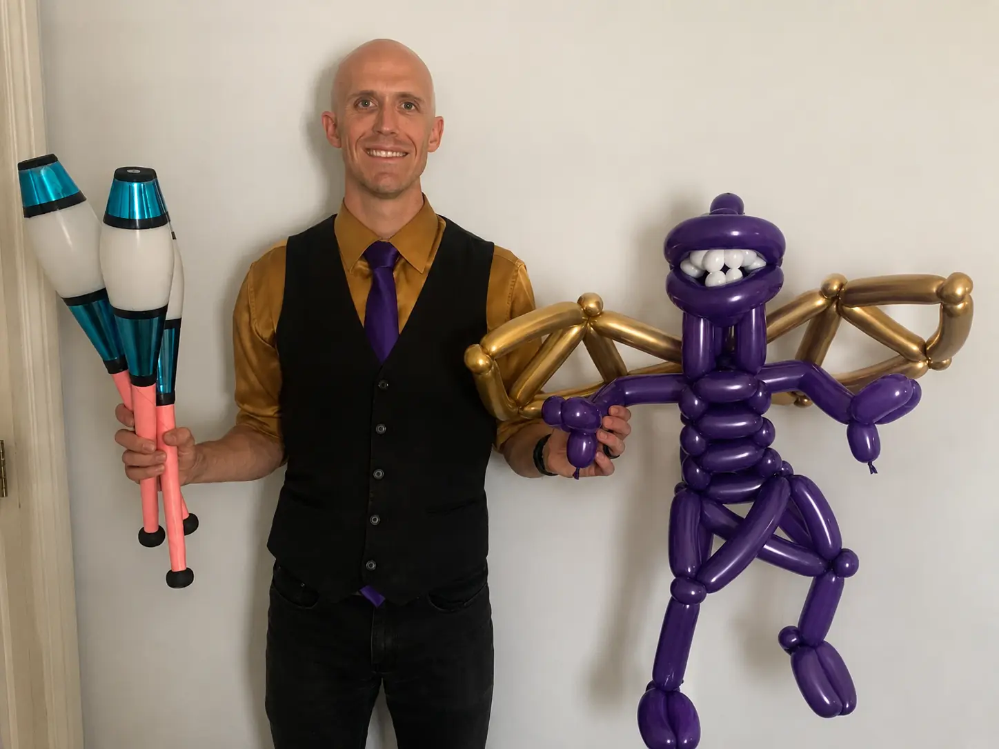 Dan with juggling clubs and a large purple balloon creation