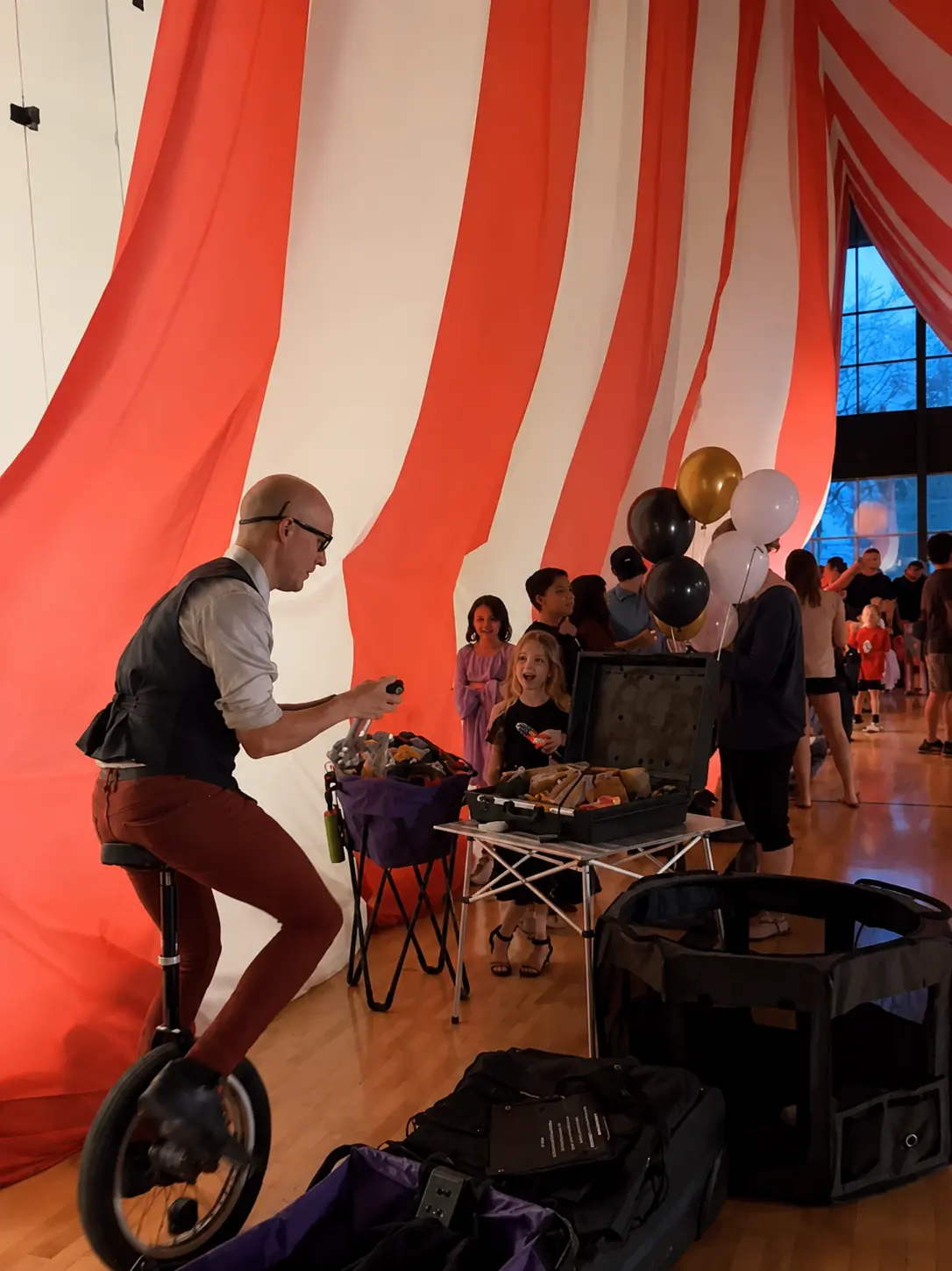 Dan twisting balloons while balancing on a unicycle