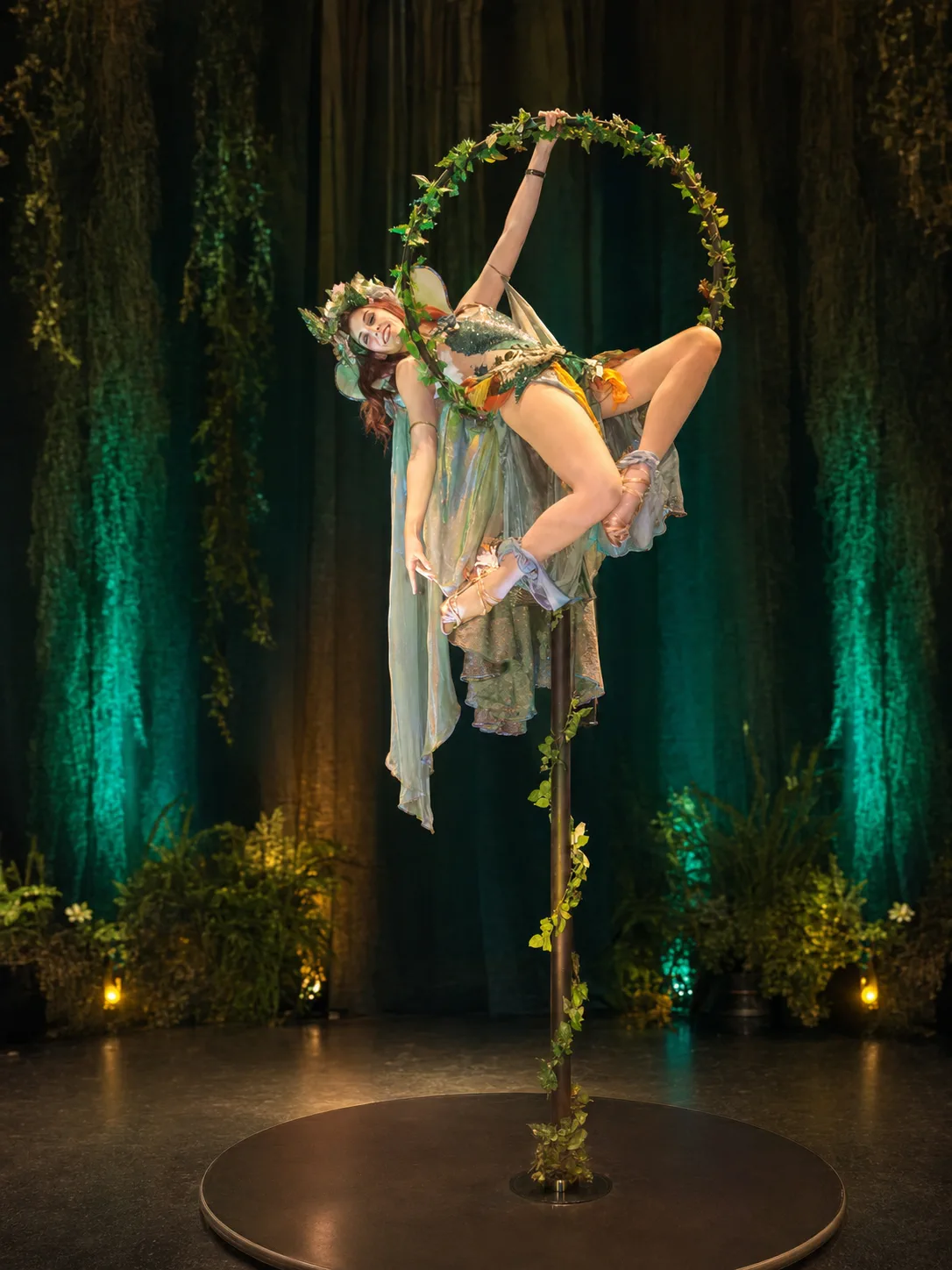 Fairy-costumed aerialist posing on a freestanding aerial lollipop apparatus