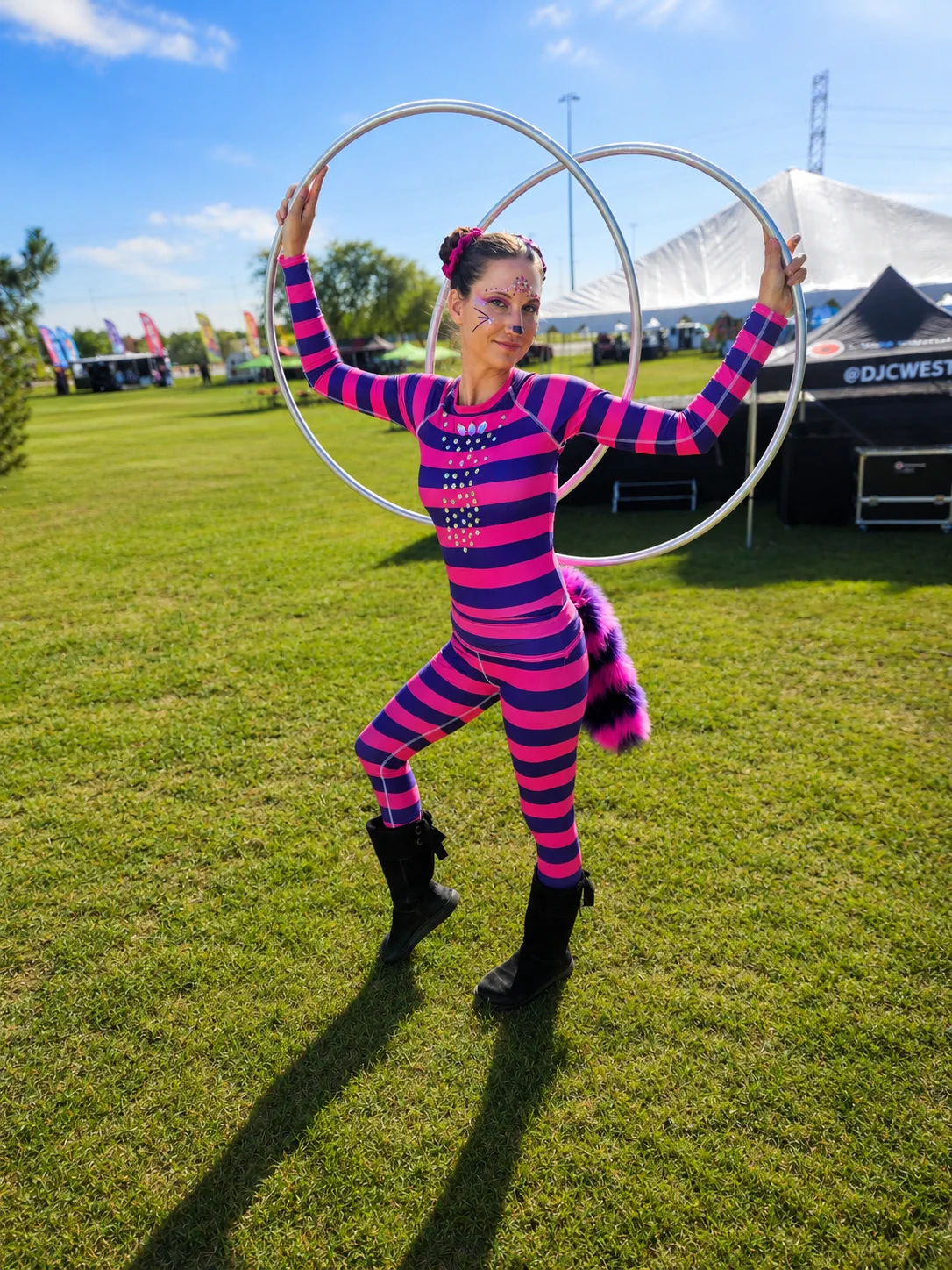 Tabitha in a Cheshire Cat-inspired Alice in Wonderland costume posing with multiple hoops