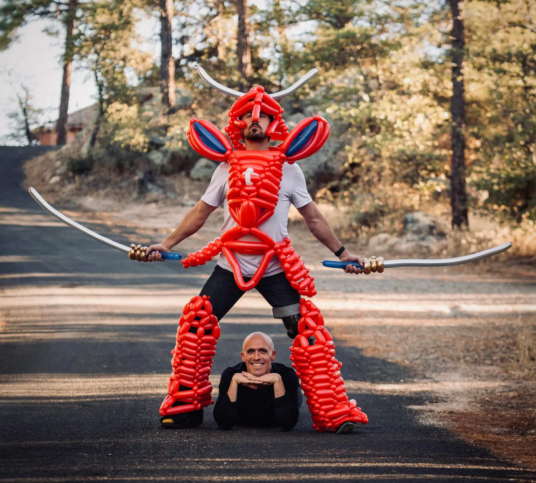 Performer wearing an elaborate red balloon sculpture with balloon swords