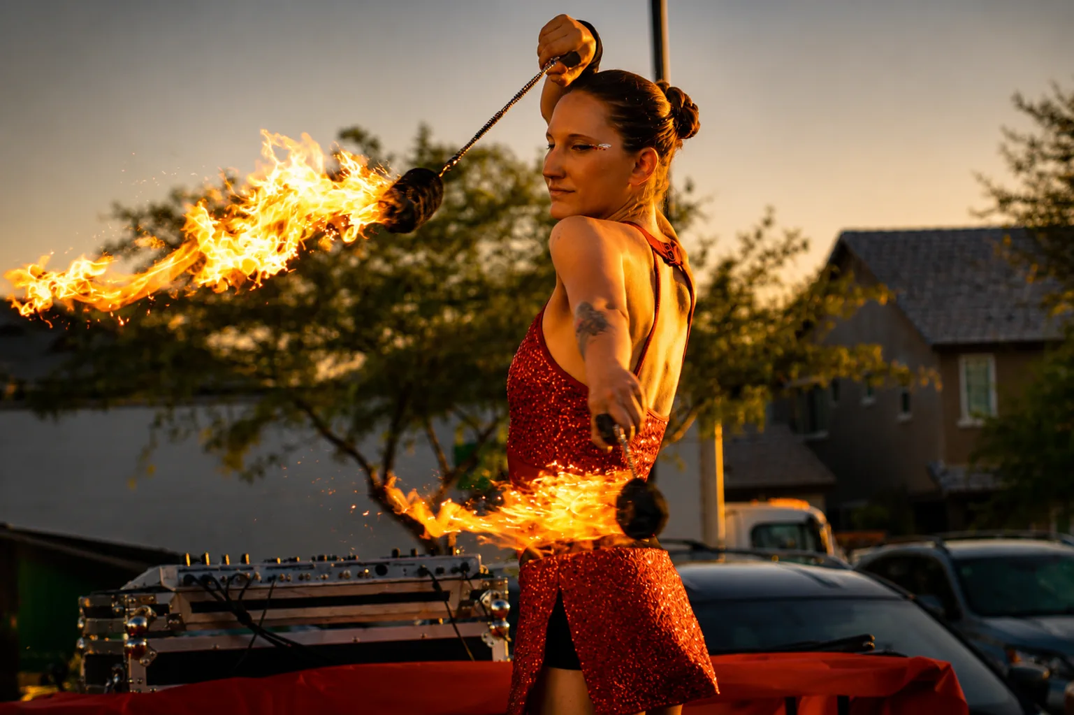 Tabitha performing with two large fire poi at sunset