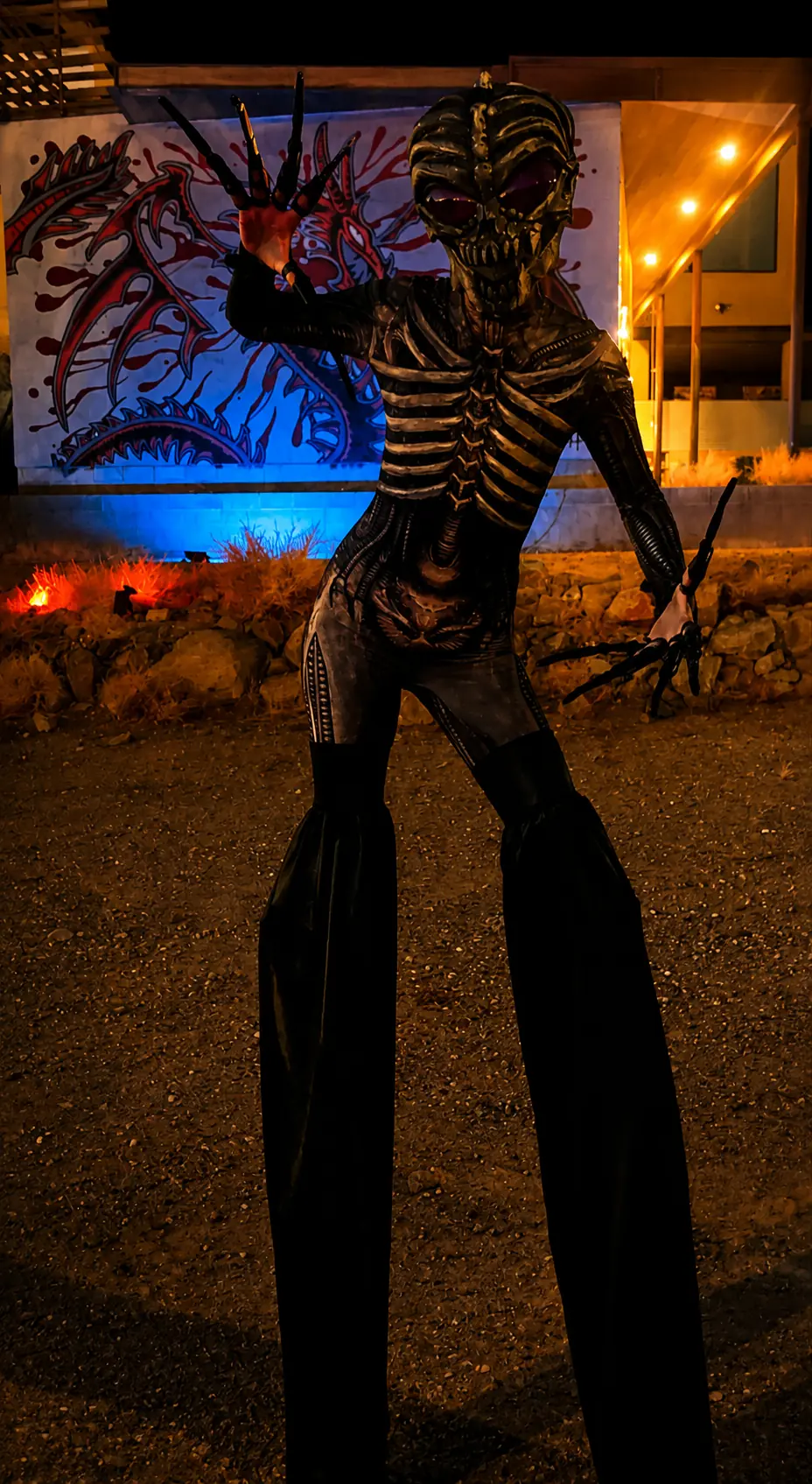 Skeleton creature performer on stilts in an elaborate black Halloween costume