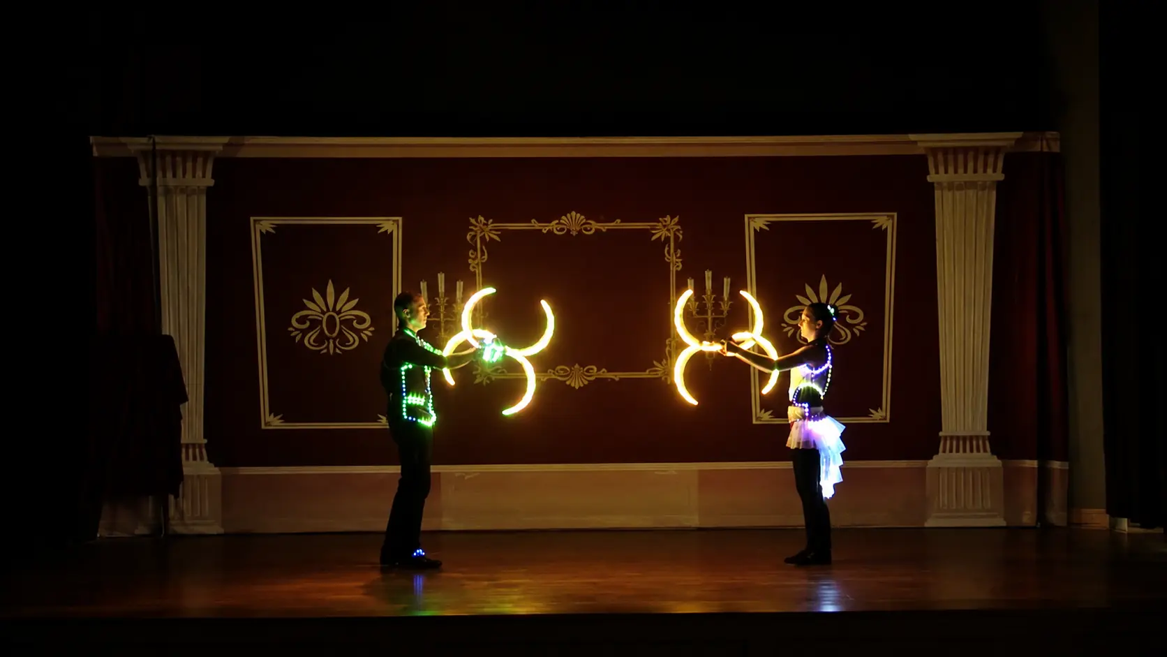 Dan and Tabitha performing synchronized illuminated buugeng on a theater stage