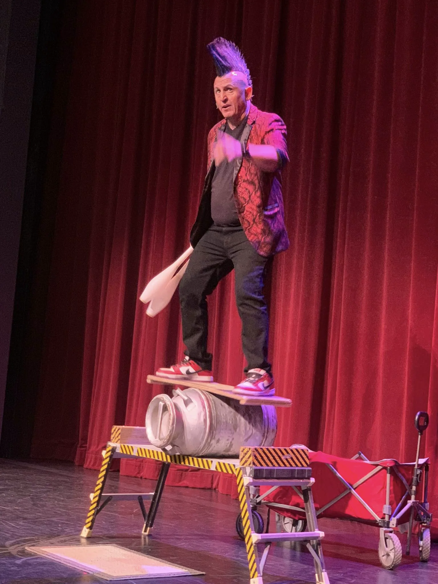 Stevie balancing on a board and roller during a theater variety show