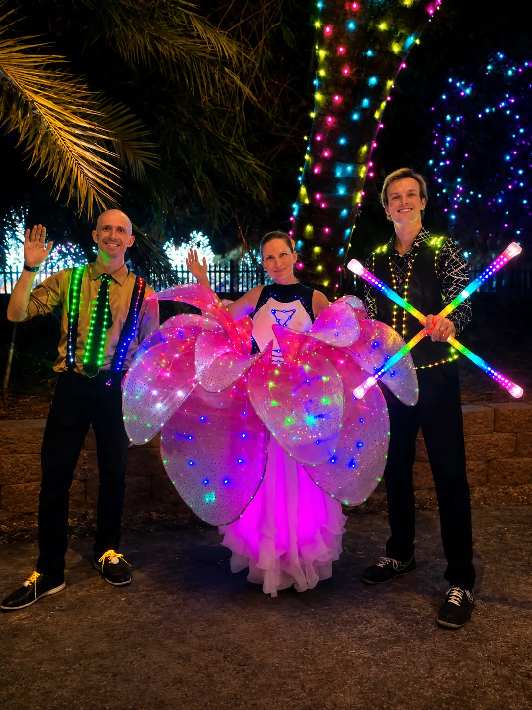 SpinElements performer in illuminated wings at a nighttime event